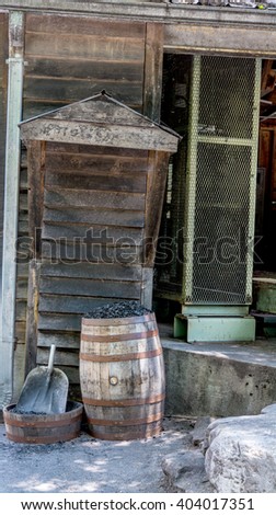 Old building with barrel of coal and shovel