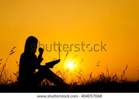 Happy Business woman holding laptop  at sunset silhouette.