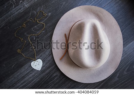 Vintage gray hat and accessory on wooden background.