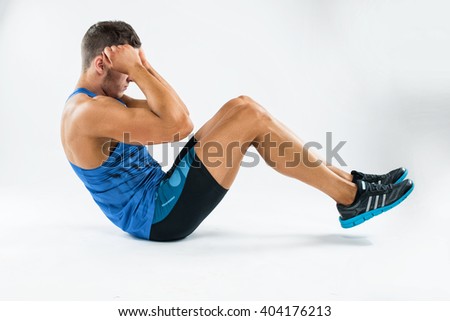 one caucasian man exercising crunches fitness weights exercises in studio.  Royalty-Free Stock Photo #404176213