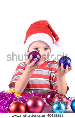 Boy in a Santa hat chooses Christmas decorations