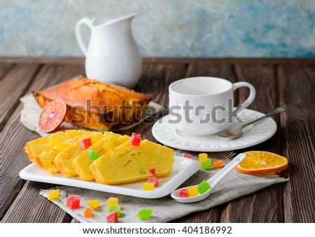 Orange cake with candied fruits on wooden background, selective focus