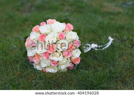 White and pink wedding bouquet isolated on green grass