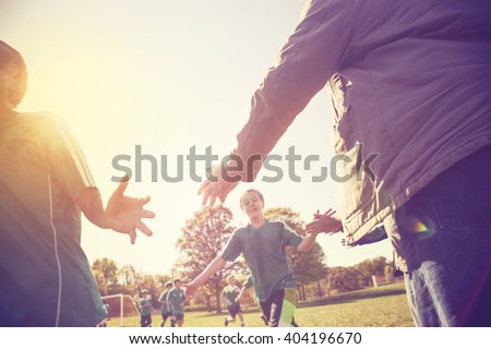 High Five line after a child's soccer game, lens flare, shot into the sunlight, Instagram image Royalty-Free Stock Photo #404196670