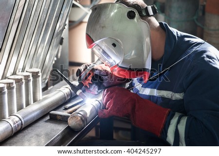 Closeup of man wearing mask welding in a workshop Royalty-Free Stock Photo #404245297