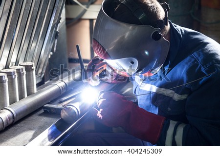 Closeup of man wearing mask welding in a workshop Royalty-Free Stock Photo #404245309