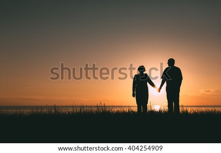 Adult couple silhouettes at sunset. Evening photo.