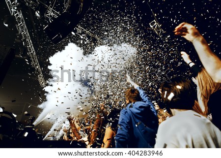 night party festival crowd of people silhouettes hands up with confetti Royalty-Free Stock Photo #404283946