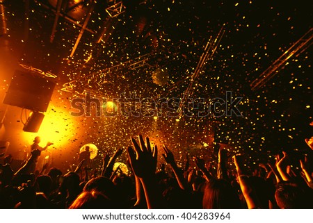 night party festival crowd of people silhouettes hands up with confetti Royalty-Free Stock Photo #404283964