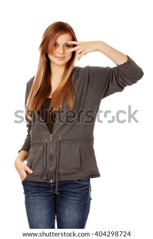 Teenage woman with victory sign on eye
