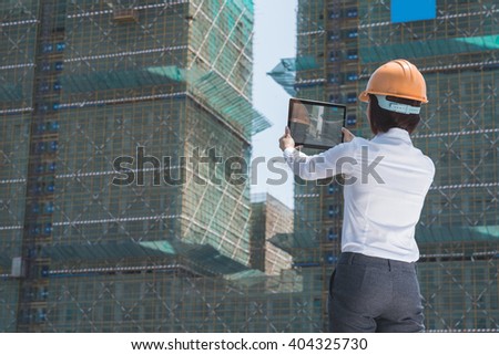 Female investor taking photo of building at the construction site