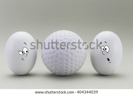 Two eggs look with strange face to a balloon of golf