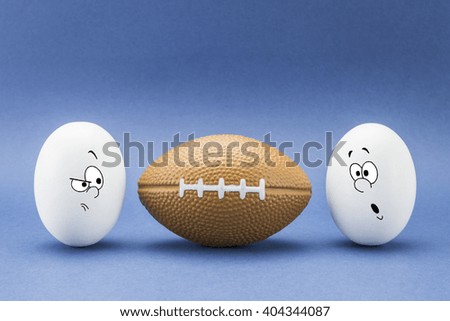 Two eggs look with strange face to a balloon of rugby