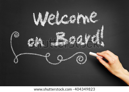 Hand writes "Welcome on board!" on blackboard