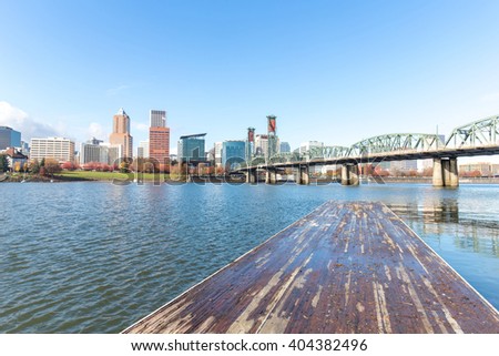 cityscape and skyline of portland on view from dirty wood planform of pier