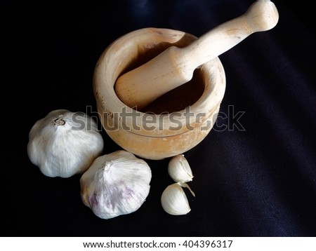 Mortar and garlics on black background