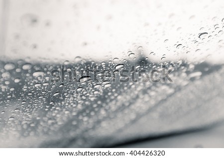 Drops of rain on glass background in monochrome.
