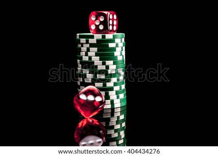 Dice and chips isolated on black background with reflection