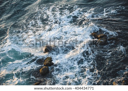 sea waves and stones at sunset light