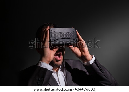 amazed young businessman using a VR headset and experiencing virtual reality