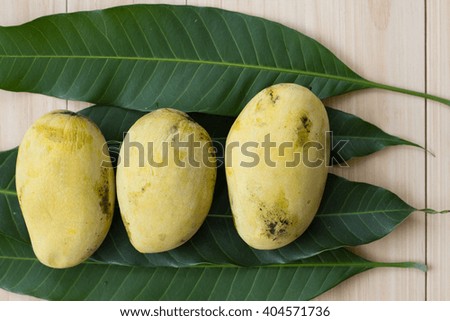 Ripe mango with leaves on  wood table