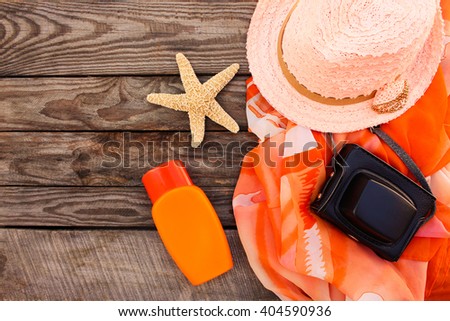 Summer women's beach accessories for your sea holiday on the old wooden background. Toned image.  