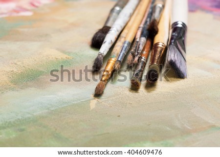 Old oil brush lying on a painted canvas. Expressive base or background. The concept of creative ideas, artistic education, painting