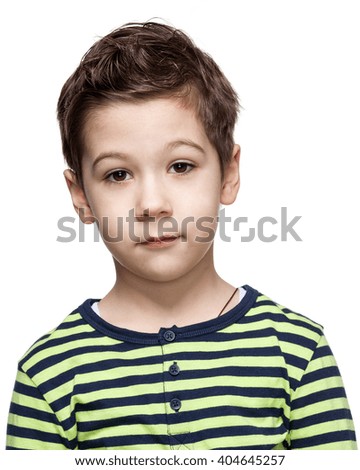 Close up portrait of a puzzled  little boy in a striped shirt, white background