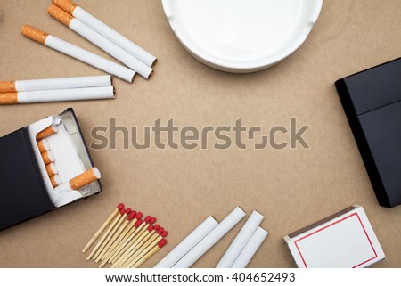 Cigarette,box,match sticks and ashtray on brown background
