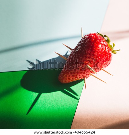 a solitary skewered strawberry, minimal pop style and design