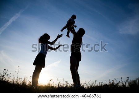 Young family happy play on the coast of background sunrise