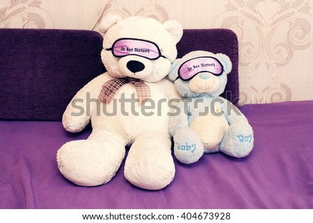 teddy bears on a violet sofa with a bandage in the eyes