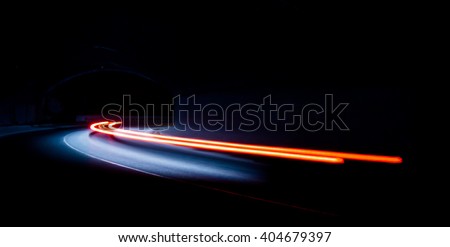 Truck light trails in tunnel. Art image . Long exposure photo taken in a tunnel  Royalty-Free Stock Photo #404679397