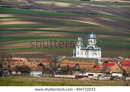 Spring plowing land near a village and church