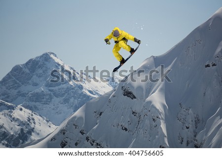 Snowboard rider jumping on mountains. Extreme snowboard freeride.