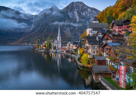 Scenic picture-postcard view of famous historic Hallstatt mountain village with Hallstatter See in the Austrian Alps in twilight during blue hour at dawn in fall, region of Salzkammergut, Austria