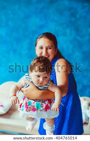 beautiful young mother holds daughter on hands
