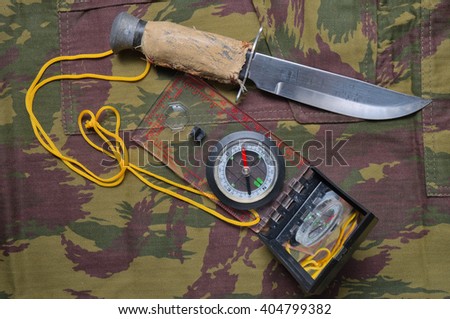 Military camo pants, compass and knife. Tactical and survival outdoor theme