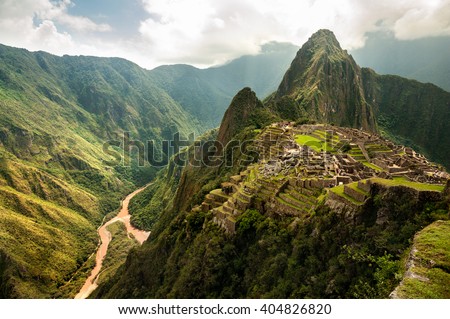 The ancient city of Machu Picchu, Peru. Overlooking ruins on the Inca citadel in the Andes Mountains and the river valley below Royalty-Free Stock Photo #404826820
