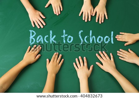 Children hands on blackboard background