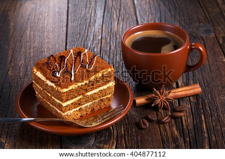 Cup of hot coffee and honey cake on dark wooden table
