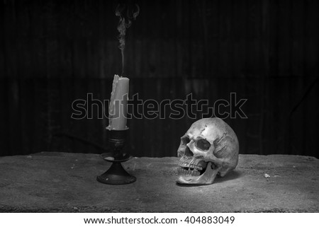 Still life photography in black and white with human Skull and Smoke form the candle.