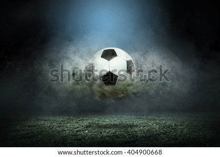 Moving soccer ball around splash drops on the stadium field. Royalty-Free Stock Photo #404900668