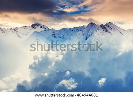 Fluffy clouds covered the mountain range. Dramatic and picturesque morning scene. Location place: Swiss alps, Europe. Mountain resort. Artistic picture. Beauty world.