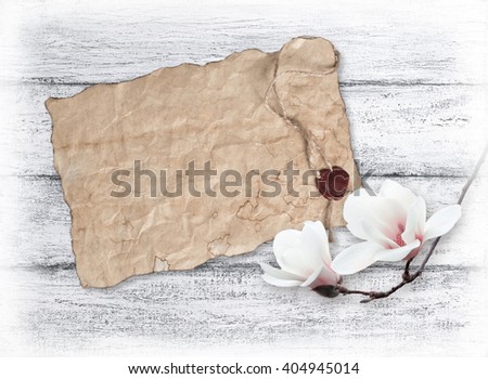 White magnolia and old paper with sealing wax on background of shabby wooden planks 