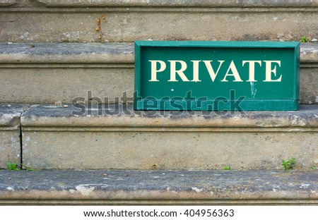 Old Private sign standing on weathered stone steps