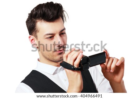 Young adult man holding an HD camcorder isolated on white background