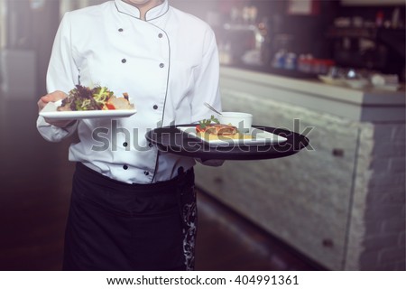 Waiters carrying plates with meat dish at a wedding Royalty-Free Stock Photo #404991361