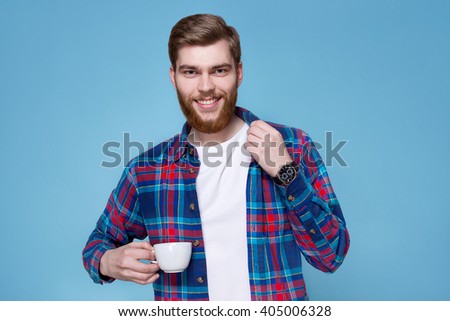 
a young man in a plaid shirt drinking coffee