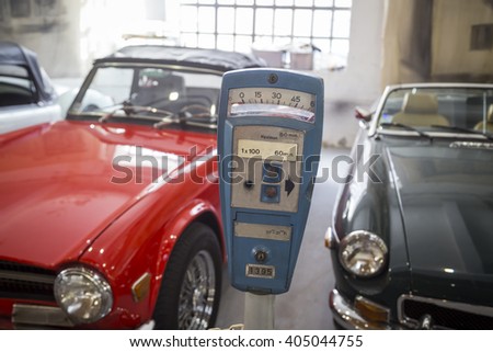 Vintage parking meter in the city garage and a row of cars.